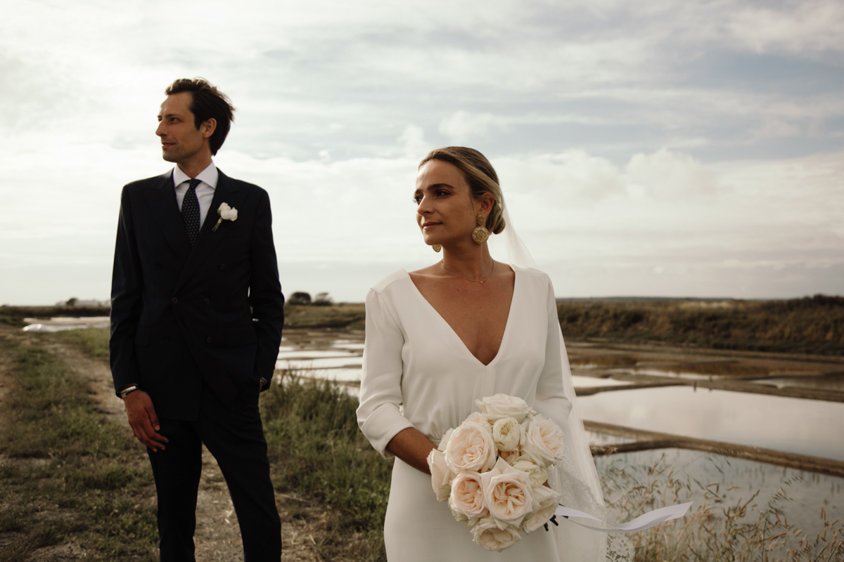 photo de couple plage bouquet de fleurs robe de mariee sur mesure costume sur mesure mariage chic elegant la baule