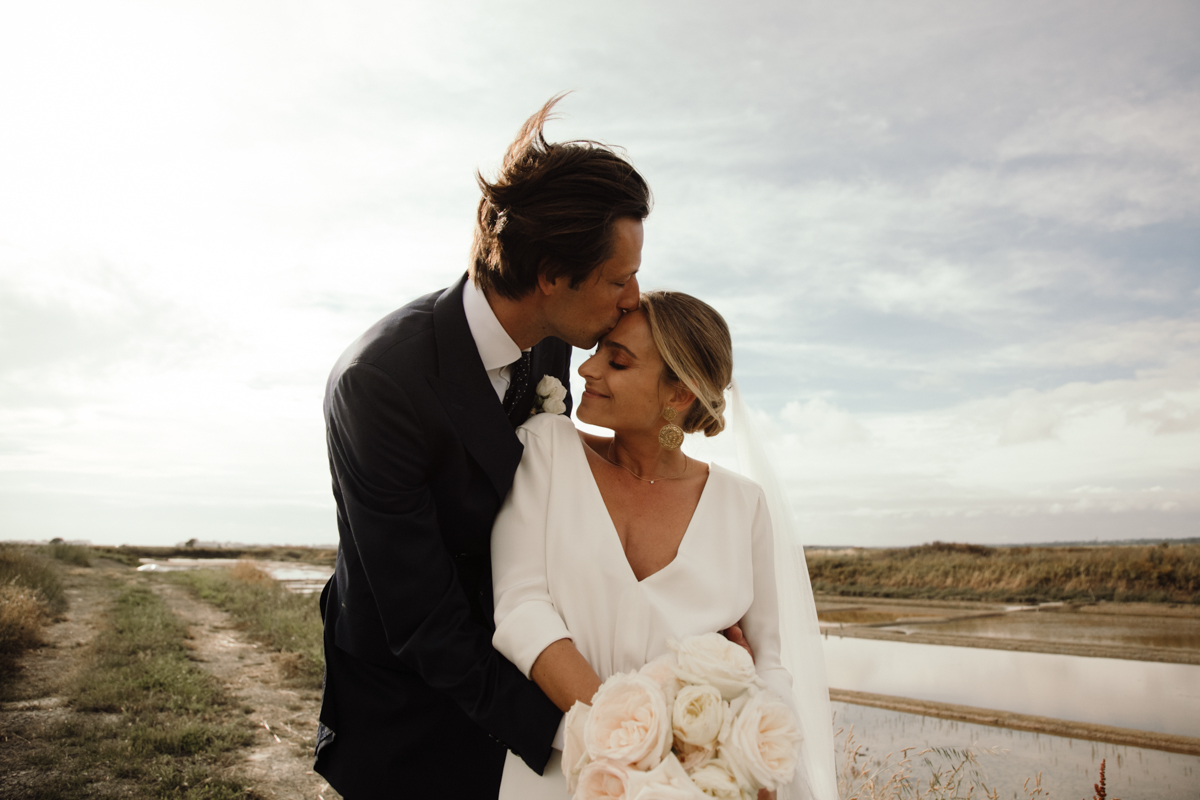 photo de couple plage la baule bouquet de fleurs robe de mariee sur mesure costume sur mesure mariage elegant chic