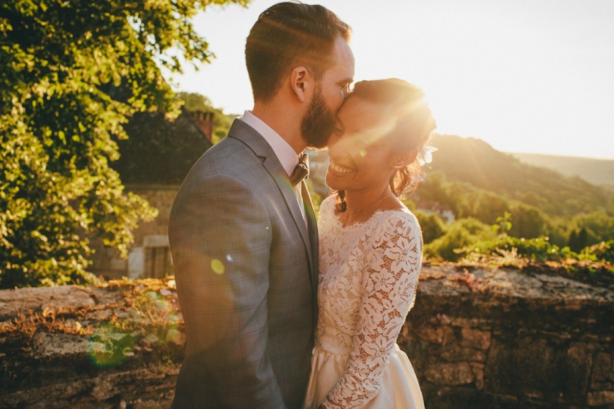 Mariés illuminés par la lumière dorée du coucher de soleil, créant une ambiance romantique
