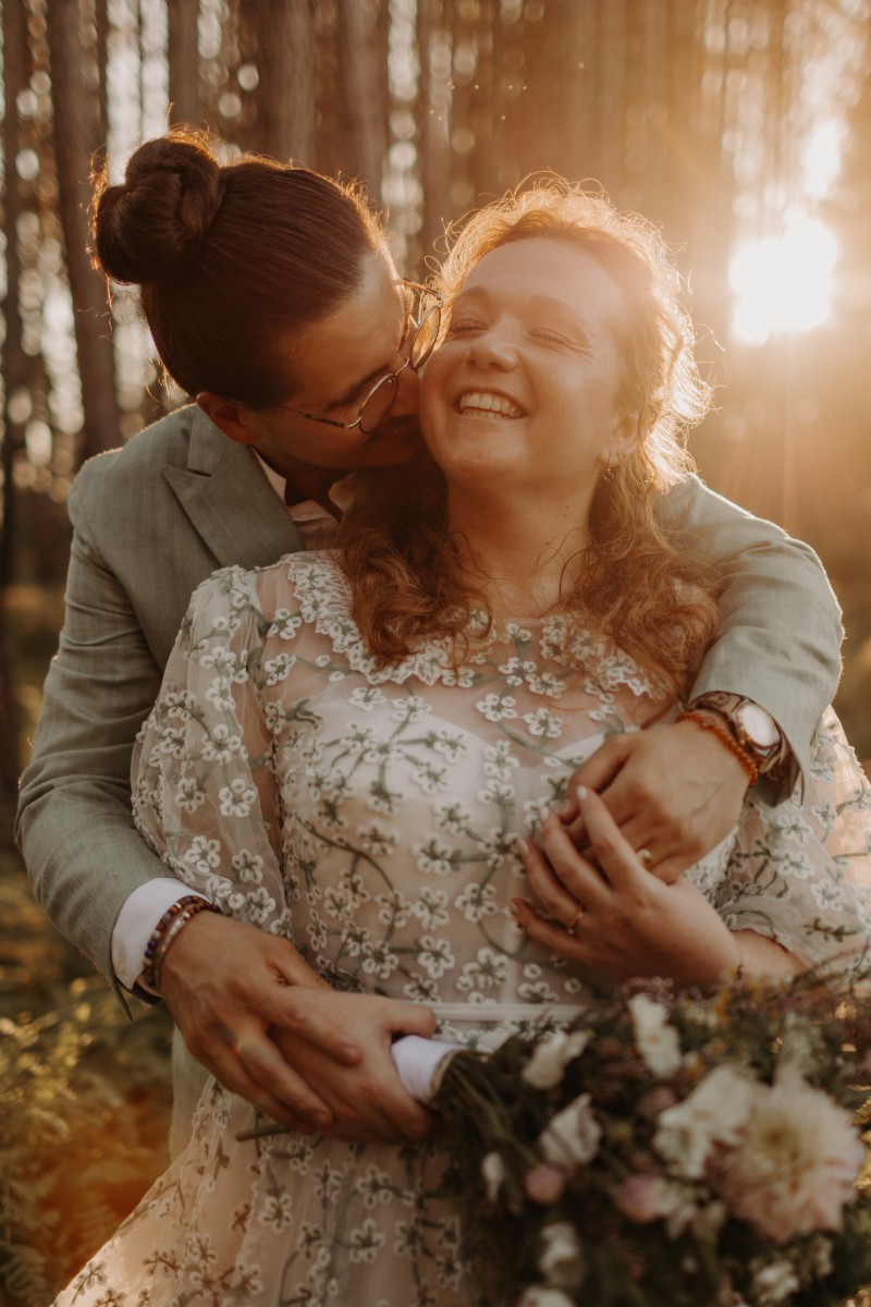 Mariés illuminés par la lumière dorée du coucher de soleil, créant une ambiance romantique