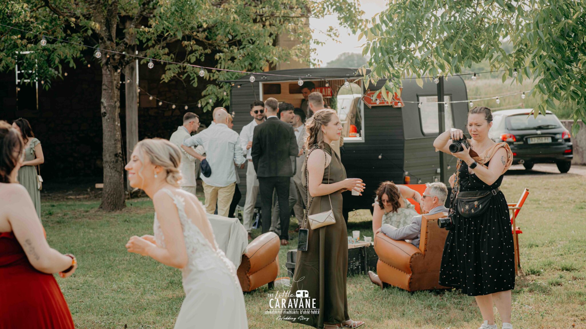 Caravane vintage aménagée en bar à vinyles et bar à bières pour mariage, installée en extérieur dans une ambiance guinguette.