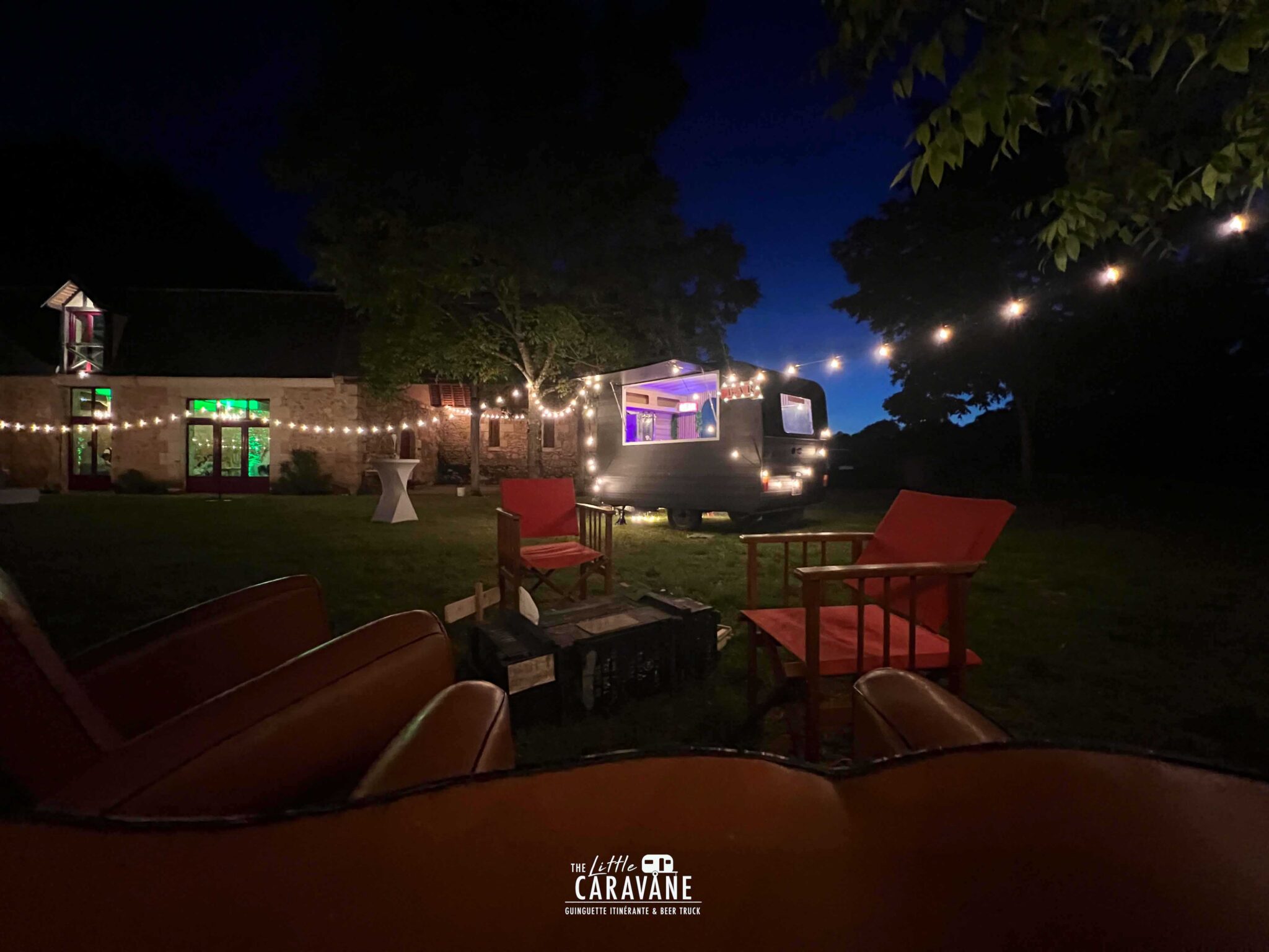 Caravane vintage aménagée en bar à vinyles et bar à bières pour mariage, installée en extérieur dans une ambiance guinguette.