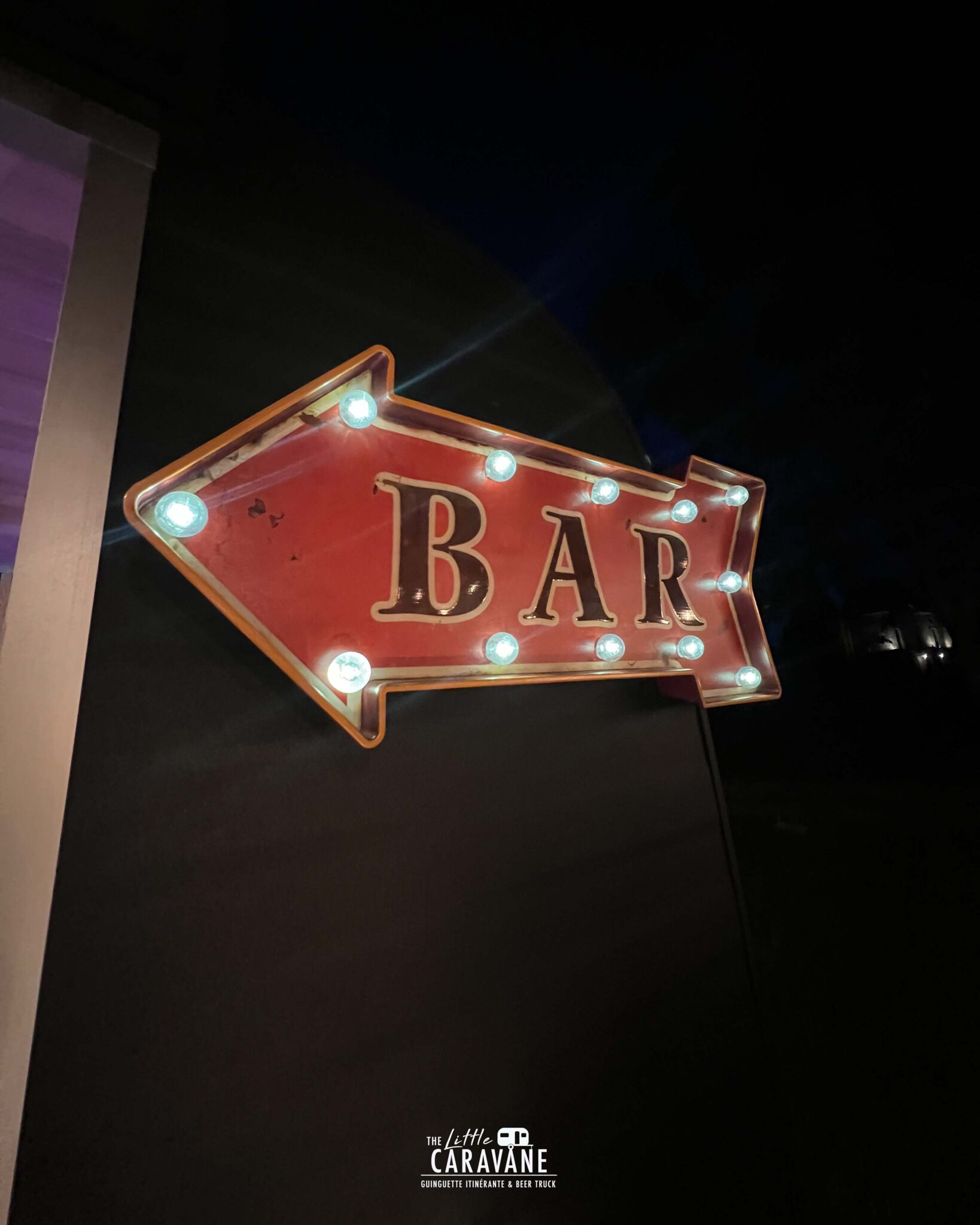 Caravane vintage aménagée en bar à vinyles et bar à bières pour mariage, installée en extérieur dans une ambiance guinguette.