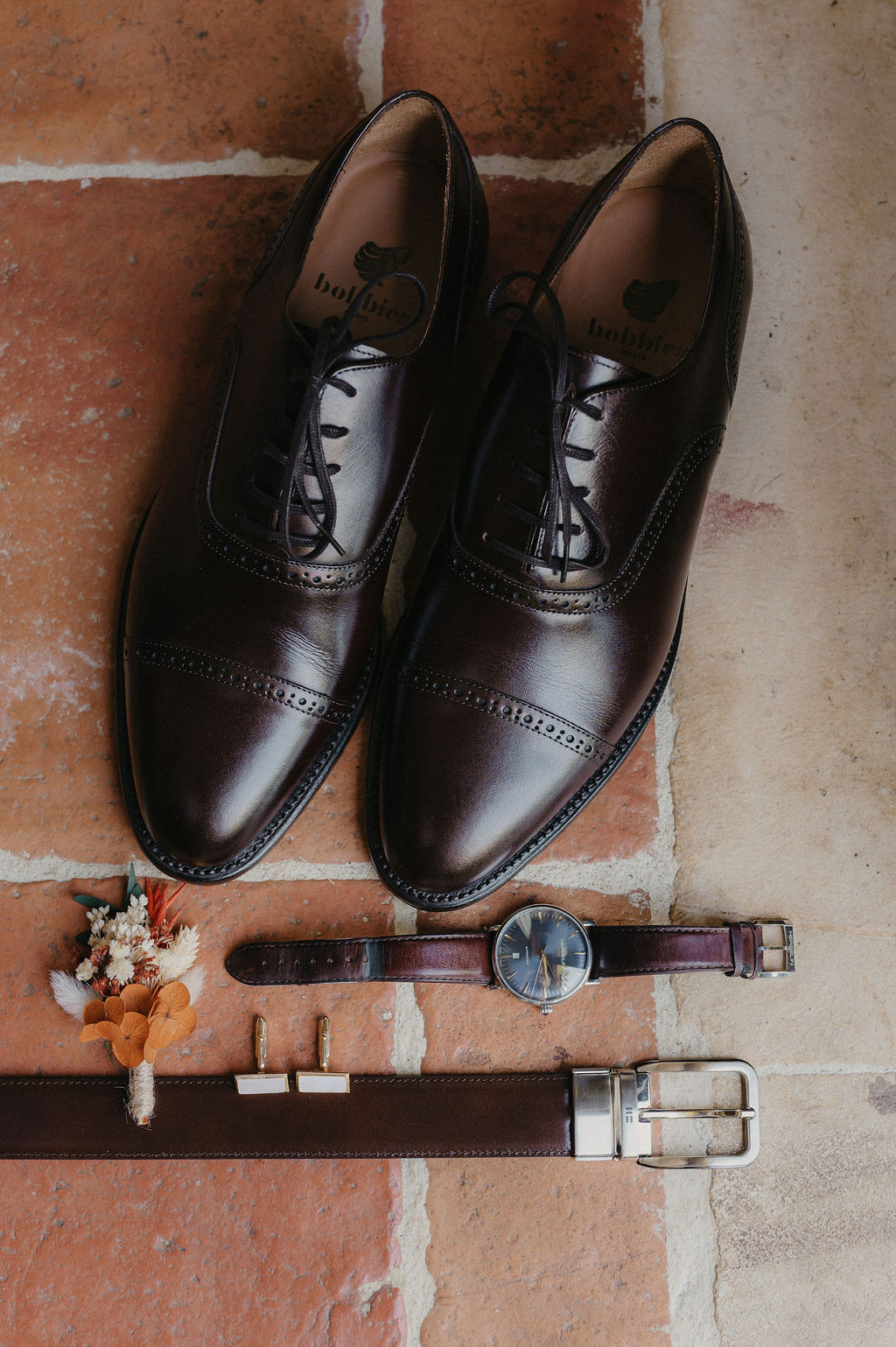 Flat lay des accessoires du marié, chaussures, montre, boutonnière