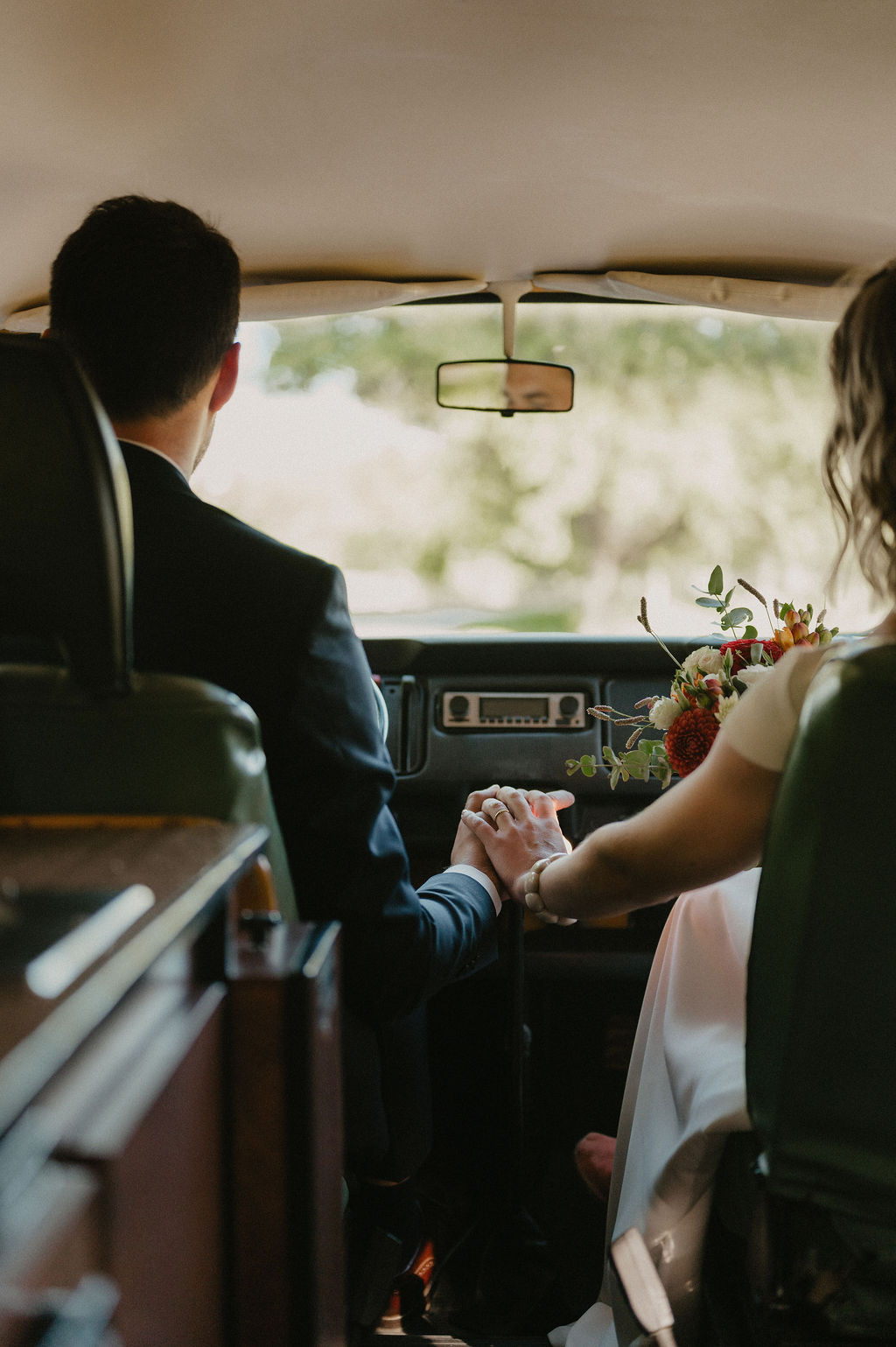 couple de jeune mariés revenant de l'égliqe dans un van vintage loué pour l'occasion