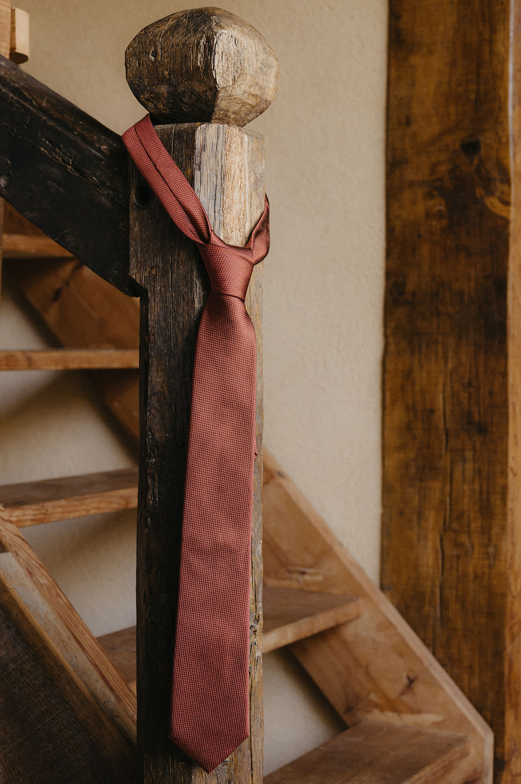 cravatte du mariée posée sur la rampe de l'escalier en attendant que le marié ne s'habille