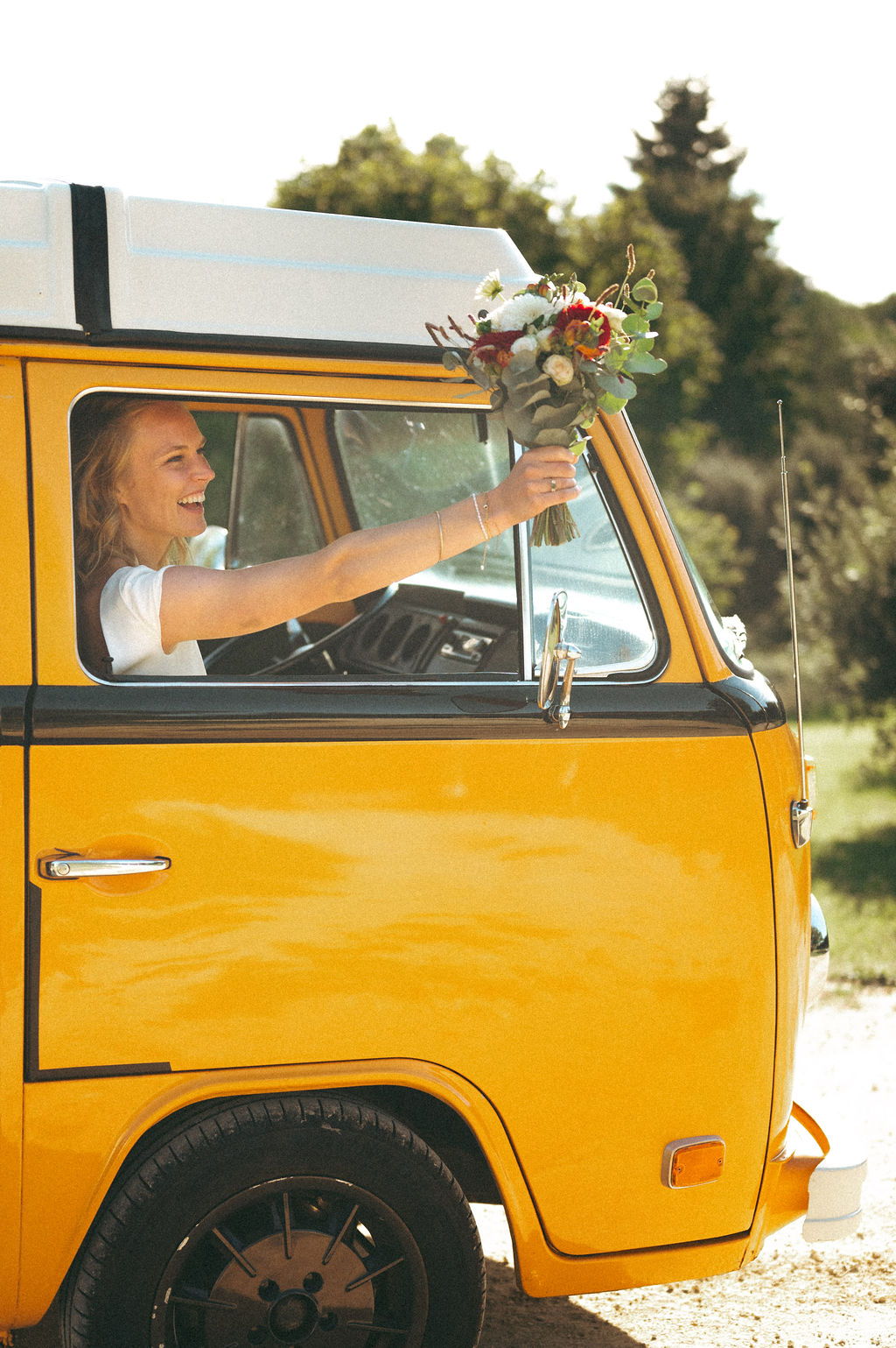 une mariée au volant d'un van vintage loué pour un mariage champetre en dordogne