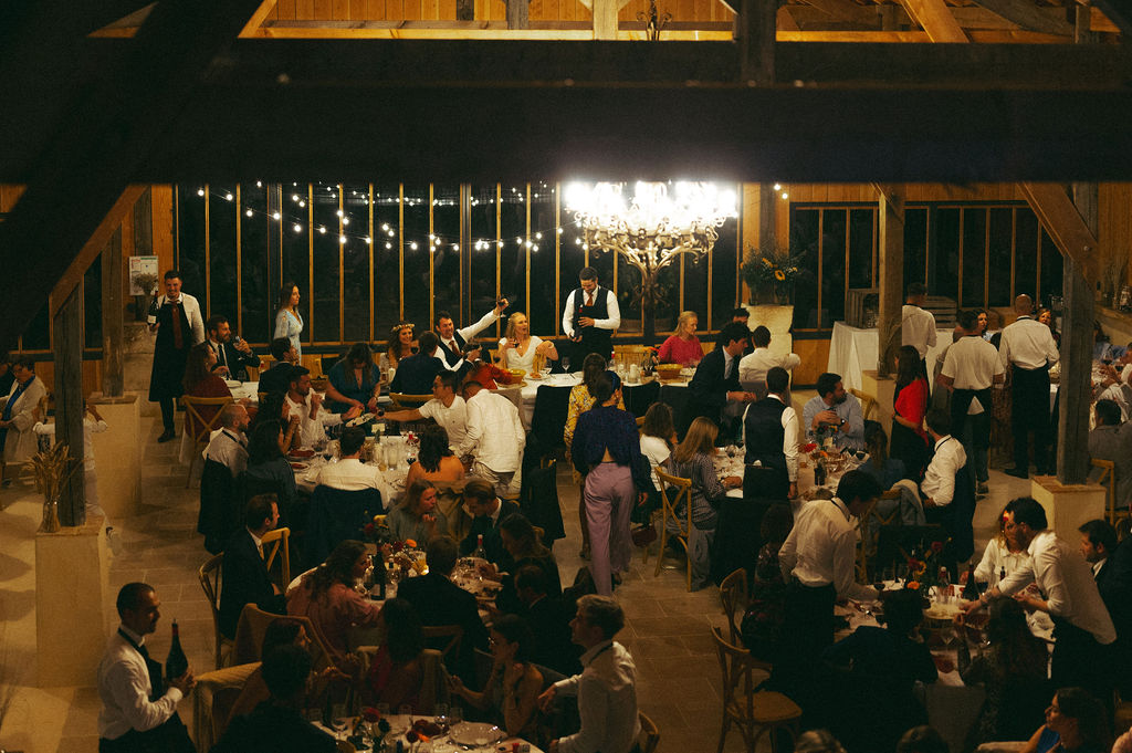 ambiance festive et conviviale lors d'un diner de mariage dans une grange renovée en dordogne