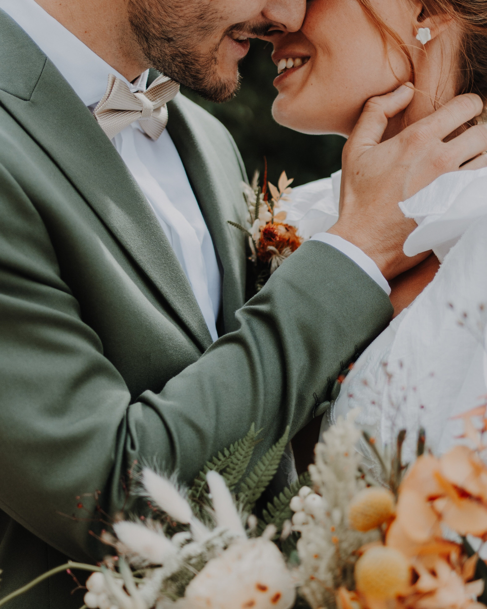 baiser d'un couple de jeune marié lors d'un mariage ecoresponsable avec costume en location pour le marié