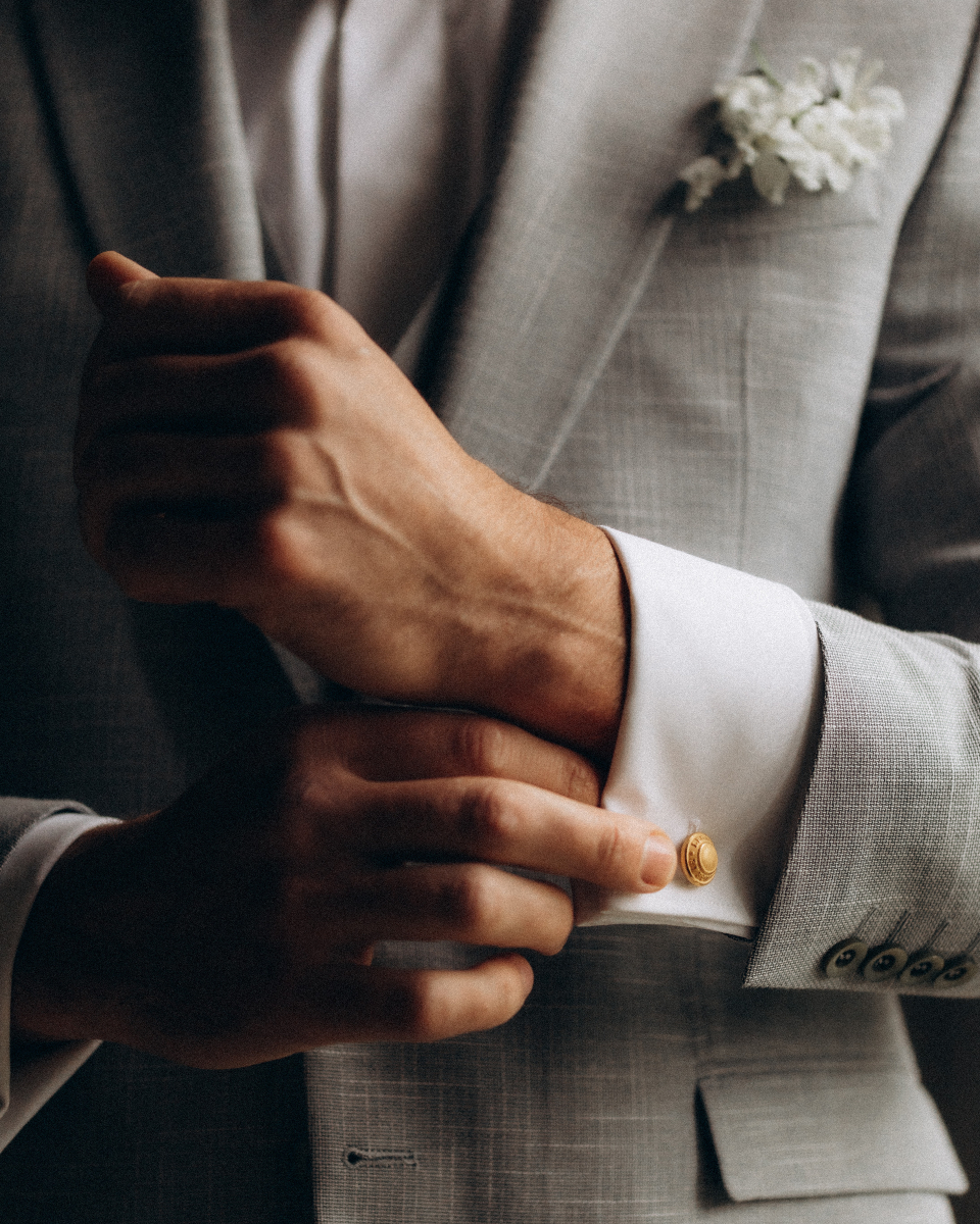 marié qui ajuste sa manche et ses boutons de manchette à son costume de mariage loué à Bordeaux