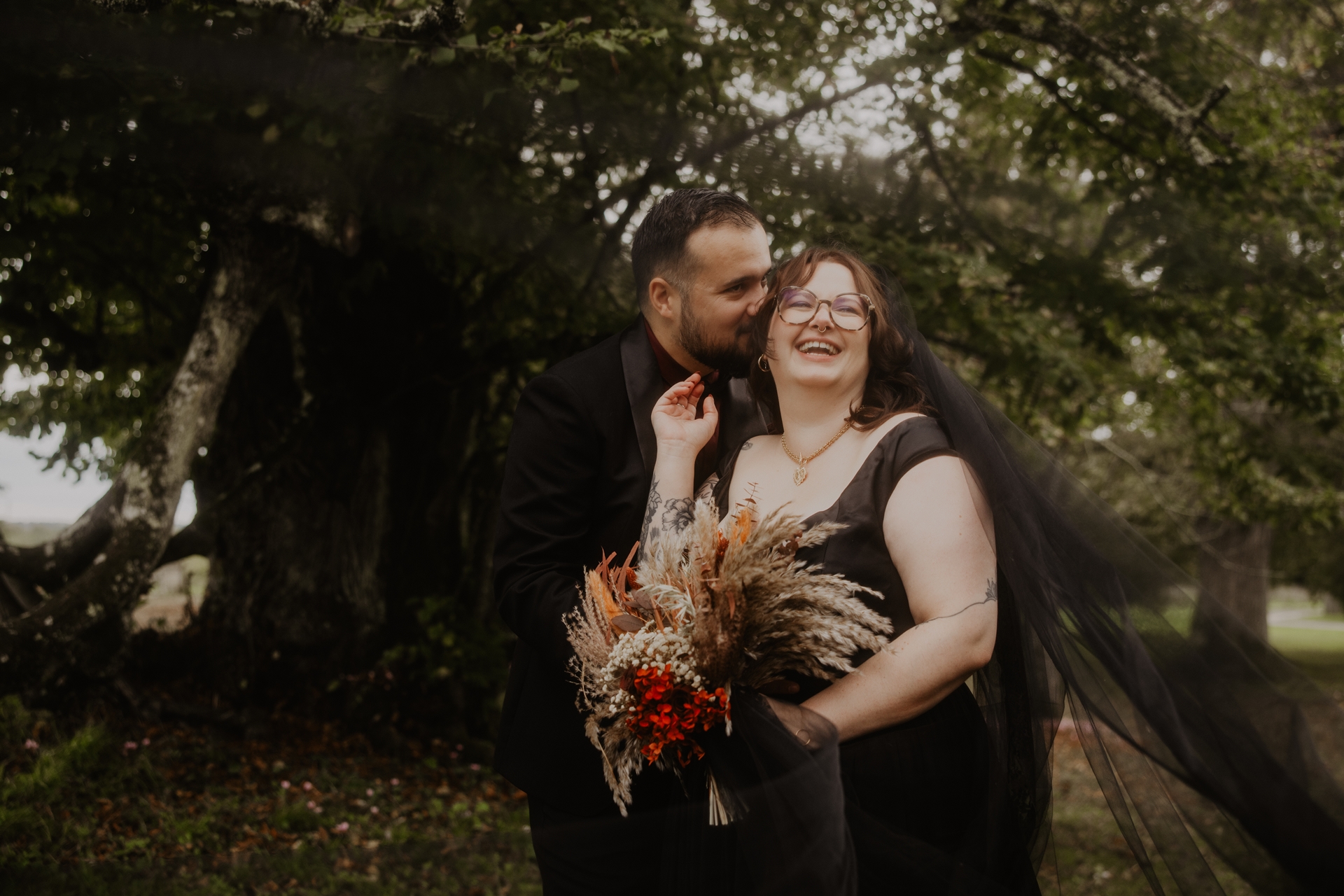 couple de mariés gothiques habillés de noir et bouquet de fleurs séchées