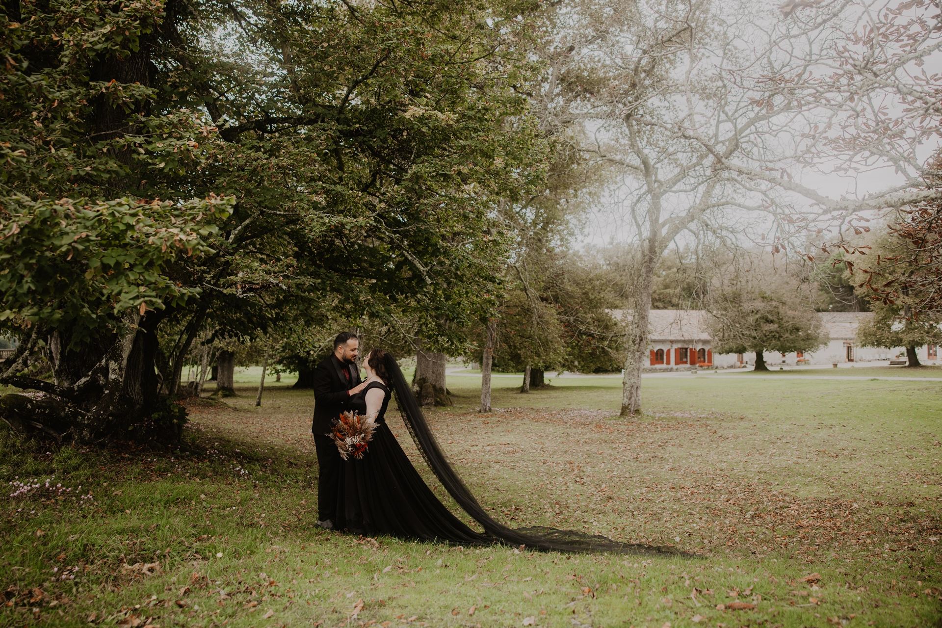 couple de mariés gothiques habillés de noir dans le parc du chateau du Taillan