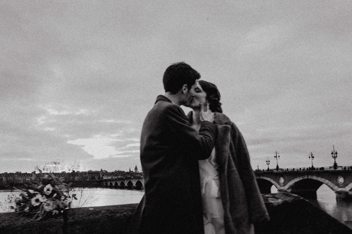 couple de mariés s'embrassant sur le pont de pierre à Bordeaux en hiver